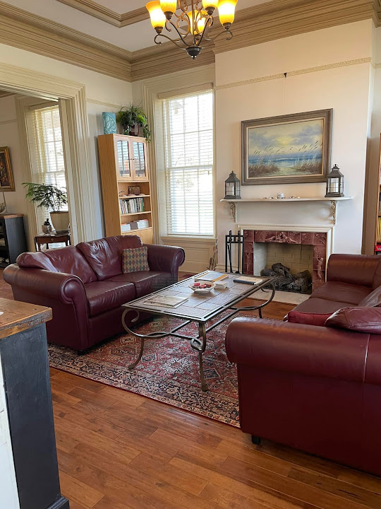 Red sofas and fireplace in The Tiskilwa Inn sitting room
