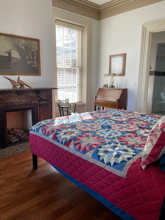 Guest bedroom with a colorful quilt at The Tiskilwa Inn